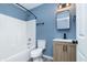 Updated bathroom with a shower-tub combo, modern vanity, and contemporary fixtures, featuring modern gray flooring at 2402 Adams St, Indianapolis, IN 46218