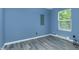 Bedroom featuring sleek gray flooring, blue walls, and a bright window at 2402 Adams St, Indianapolis, IN 46218