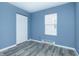 Cozy bedroom with modern gray walls, a window with blinds, and modern gray flooring at 2402 Adams St, Indianapolis, IN 46218