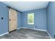 Stylish bedroom featuring a modern barn door, sleek gray flooring, and a bright window at 2402 Adams St, Indianapolis, IN 46218