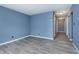 Bright bedroom with gray wood flooring, neutral walls and adjacent hallway at 2402 Adams St, Indianapolis, IN 46218