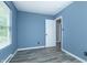 Light-filled bedroom featuring sleek gray floors, calming blue walls, and a bright white door at 2402 Adams St, Indianapolis, IN 46218