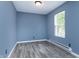 Cozy bedroom with gray wood flooring, a bright window, and neutral wall paint at 2402 Adams St, Indianapolis, IN 46218