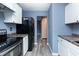 Bright kitchen with white cabinets, dark countertops, stainless steel appliances, and modern gray flooring at 2402 Adams St, Indianapolis, IN 46218