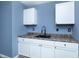 Modern kitchen featuring white cabinets, dark countertops, a black faucet, and contemporary gray flooring at 2402 Adams St, Indianapolis, IN 46218
