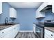 Bright kitchen with white cabinets, dark countertops, and stainless steel appliances, complemented by modern gray flooring at 2402 Adams St, Indianapolis, IN 46218