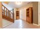 Inviting entryway with tile flooring, wooden shelving, and a staircase leading to the upper level at 2875 Prairie Stream Way, Columbus, IN 47203