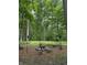 Outdoor fire pit encircled by mature trees and natural wooden seating for relaxing in nature at 2875 Prairie Stream Way, Columbus, IN 47203