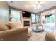 Comfortable living room with a fireplace, mounted TV, and an open layout flowing into the sunroom at 2875 Prairie Stream Way, Columbus, IN 47203