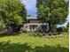 Expansive backyard featuring mature trees, lush landscaping, a patio area, and an outdoor fireplace at 319 Mcintosh Ln, Westfield, IN 46074