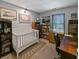 Multi-purpose room with a crib, desk, and multiple bookcases with natural light coming in at 319 Mcintosh Ln, Westfield, IN 46074