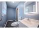 Bathroom with wood-look flooring, toilet, and vanity with modern, light-up mirror at 3457 W 58Th St, Indianapolis, IN 46228