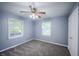 Bright bedroom with plush carpet, ceiling fan, closet, and ample natural light from two windows at 3457 W 58Th St, Indianapolis, IN 46228
