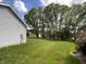 Large backyard with lush green grass and mature trees, perfect for recreation at 425 Bridgewater S Ln, Muncie, IN 47304
