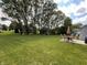 Expansive lawn featuring trees, patio furniture, a playground, and surrounding homes at 425 Bridgewater S Ln, Muncie, IN 47304