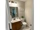 Half bathroom features wood vanity, mirror, toilet, and decorations at 425 Bridgewater S Ln, Muncie, IN 47304