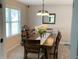 Dining room with a wooden table, seating for six, and stylish light fixture above at 425 Bridgewater S Ln, Muncie, IN 47304