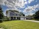 Exterior of two-story home featuring a large lawn, brick facade, and three-car garage at 425 Bridgewater S Ln, Muncie, IN 47304