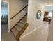 Hallway featuring carpeted stairs with wooden banister and a decorative tree art piece at 425 Bridgewater S Ln, Muncie, IN 47304