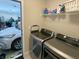 Laundry room with modern washer and dryer, shelving, and a view into the garage at 425 Bridgewater S Ln, Muncie, IN 47304