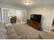 Open living room with large TV, plush seating, and glass paneled doors into the dining room at 425 Bridgewater S Ln, Muncie, IN 47304