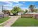 A spacious backyard with a gravel driveway leading to a detached garage, enclosed by a wooden fence at 4337 English Ave, Indianapolis, IN 46201