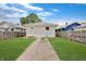 Detached garage with fresh white paint, a gravel driveway, and a green lawn at 4337 English Ave, Indianapolis, IN 46201