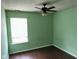 A light green bedroom features a window, hardwood floors, and a ceiling fan at 4456 Redcliff N Ln, Plainfield, IN 46168
