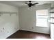 A white bedroom features a window, hardwood floors, a ceiling fan, and shelving at 4456 Redcliff N Ln, Plainfield, IN 46168