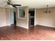 Living room featuring wood floors, neutral walls, ceiling fan, and view of kitchen area at 4456 Redcliff N Ln, Plainfield, IN 46168