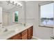 Bright bathroom with double vanity and scenic backyard view through the window at 4506 Tarragon Dr, Indianapolis, IN 46237