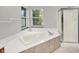 Bathroom featuring large soaking tub with window and a glass enclosed shower at 4506 Tarragon Dr, Indianapolis, IN 46237
