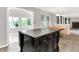 This kitchen features a center island with storage and countertops, connecting to a dining area and sunroom with large windows at 4506 Tarragon Dr, Indianapolis, IN 46237