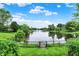 Scenic view of a lake from the backyard, framed by a black chain-link fence and lush green vegetation at 4506 Tarragon Dr, Indianapolis, IN 46237