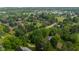 Aerial view of a neighborhood with mature trees and a lake in the distance at 5160 N High School Rd, Indianapolis, IN 46254