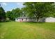 Expansive backyard featuring a well-maintained lawn, mature trees, and a charming outdoor space at 5160 N High School Rd, Indianapolis, IN 46254