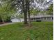 Charming single-story home with a detached garage and a beautiful, spacious front yard featuring mature trees at 5160 N High School Rd, Indianapolis, IN 46254