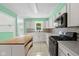 Bright kitchen features white cabinets, tile backsplash, stainless steel appliances, and wood-top island at 5160 N High School Rd, Indianapolis, IN 46254