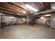 Unfinished basement with exposed wood ceiling, concrete floor, and utilities at 521 Kessler Blvd E Dr, Indianapolis, IN 46220