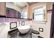 Unique bathroom featuring a vessel sink, black countertop, and white and purple tile at 521 Kessler Blvd E Dr, Indianapolis, IN 46220