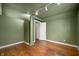 Spare bedroom with hardwood floors, green walls, and track lighting at 521 Kessler Blvd E Dr, Indianapolis, IN 46220