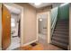 Hallway with hardwood floors leading to a bathroom and stairs at 521 Kessler Blvd E Dr, Indianapolis, IN 46220