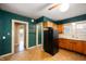An awkward kitchen with teal walls, a black refrigerator, and vintage cabinets at 521 Kessler Blvd E Dr, Indianapolis, IN 46220