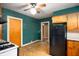 A kitchen with teal walls, a black refrigerator, and wood-toned cabinets at 521 Kessler Blvd E Dr, Indianapolis, IN 46220