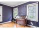 Living room featuring hardwood floors, purple accent wall, and bright windows at 521 Kessler Blvd E Dr, Indianapolis, IN 46220