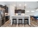 Open kitchen with an island and bar stools, stainless steel appliances, and dark cabinetry at 5304 Maywood Dr, Whitestown, IN 46075