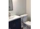 A modern bathroom with a navy vanity, white sink, and toilet for convenience at 6070 Southbay Dr, Indianapolis, IN 46250