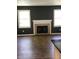 Spacious living room with a fireplace and hardwood flooring, bathed in natural light at 6070 Southbay Dr, Indianapolis, IN 46250