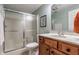 Bathroom with shower, light green walls, wooden vanity, white toilet, framed art, and white towels at 626 N Senate Ave, Indianapolis, IN 46202