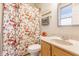 Well-lit bathroom with floral shower curtain, cream-colored vanity, and a framed mirror at 626 N Senate Ave, Indianapolis, IN 46202